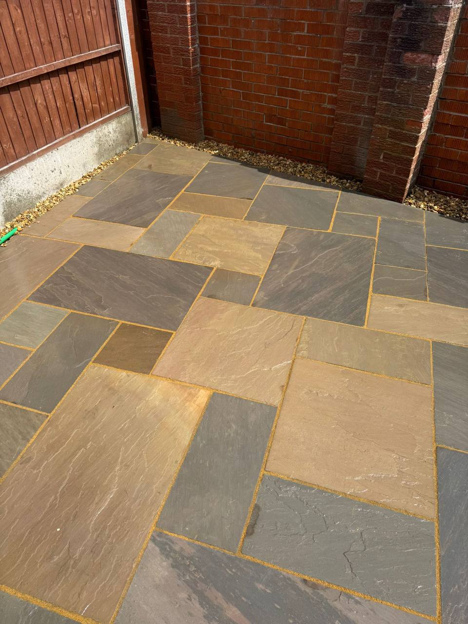Natural Indian sandstone paving flags laid in a random pattern with buff pointing