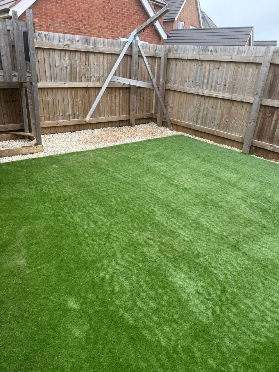 Artificial grass lawn with white gravel border and timber featheredge fencing